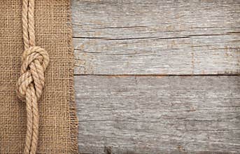 Ship rope on wood and burlap texture background