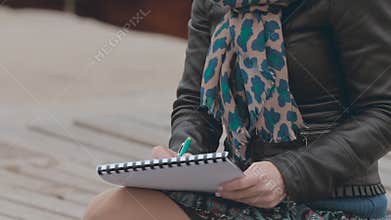 Beautiful girl drawing the anchor in pencil