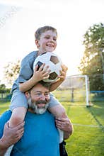Dad and son sharing passion for football and active lifestyle.