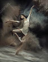 Dancing ballet dancer with dust in the background