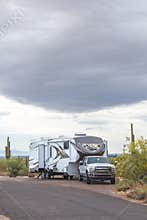 Pickup truck towing fifth wheel camper in desert