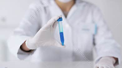 Close up of scientist with full beaker in lab