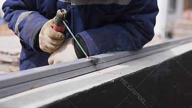 construction of a private house Skilled Builder Welds Metal Beams. Experienced Worker Performs Accurate Welding Amidst