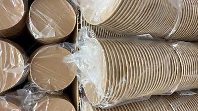 Stack of eco-friendly paper plates wrapped in plastic packaging on display in a vertical format