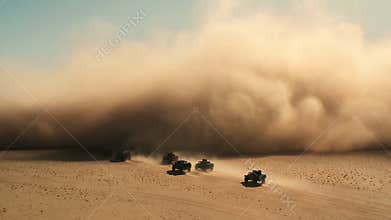 Armored convoy crossing sunlit desert toward towering sandstorm under pale cyan sky