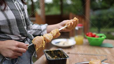 Woman preparing marinated chicken shish kebab for barbecue