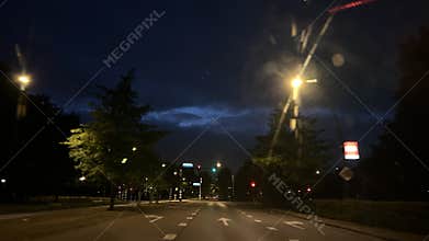 Night street scene with illuminated lamp post and apartment building windows