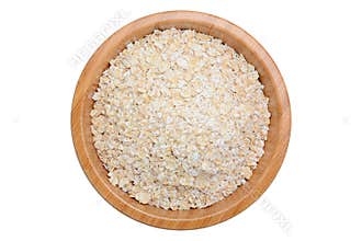 Oat flakes in wooden bowl isolated on white
