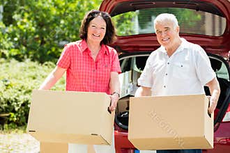 Senior Couple Standing In Front Of Car