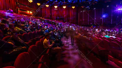 Spectators gather in the auditorium and watch the show in theatre timelapse. Large hall with red armchairs seats
