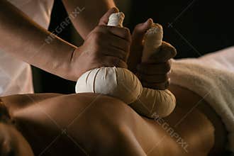 Massage with herbal balls. Luxury spa treatment