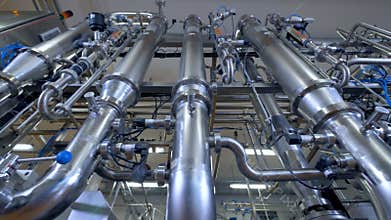 Shiny pipeline system, stainless steel pipes at industrial plant. 4K.