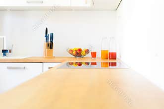 Modern kitchen counter with induction hob, fresh fruit and homemade lemonade