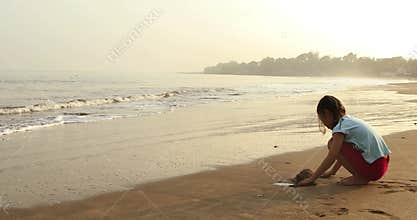 Girl playing sand alone on beach