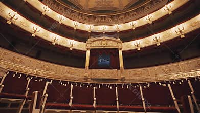 Expensive balcony in concert hall, vacant chairs rows, red draipings