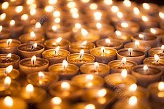 Burning bright. Golden warm glow from candle flames. Many beautiful lit tealight candles glowing.