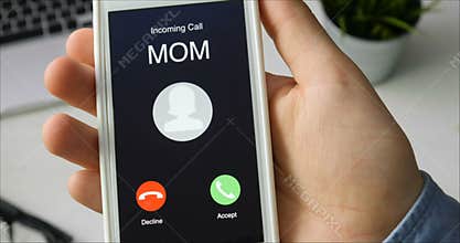 Receiving phone call from Mom and accepting. Mobile communication concept. Sitting at the desk