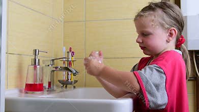 Sweet little girl washes her hands in the bathroom. Preschool concept, childhood concept. Cute girl wears nightdress