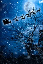Christmas background. Silhouette of Santa Claus flying on a sleigh pulled by reindeer.