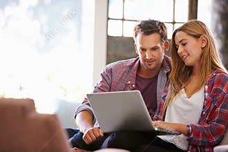 Couple At Home In Lounge Using Laptop Computer