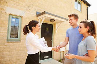 Real estate agent shaking hands with new property owners