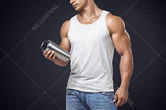 Muscular fitness male holding protein shake bottle