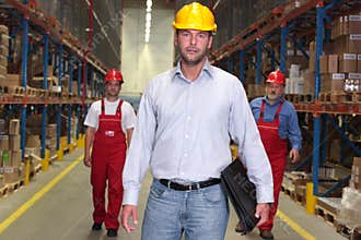 Boss with briefcase at the front of workforce