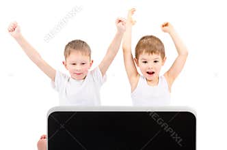 Two happy boys in front of a laptop screen