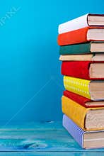 Stack of colorful books, grungy blue background, free copy space