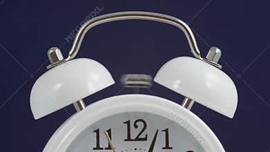 A classical analog alarm clock ringing