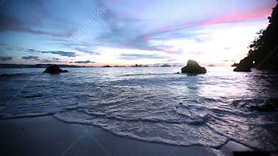 Sunset on the beach - Tranquil idyllic scene of a golden sunset over the sea, waves slowly splashing on the sand