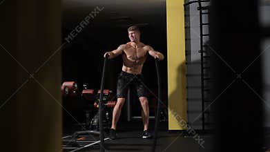 Bodybuilder funny dancing. Fitness battling ropes at gym workout fitness exercise