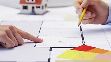 Woman and architect discussing blueprint of house