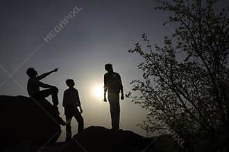 Silhouettes of people on rocks