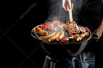 Man grilling meat on a portable barbecue