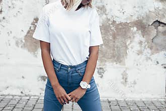 Model posing in plain tshirt against street wall