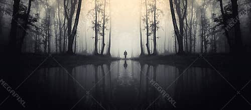 Haunted lake in forest with man silhouette