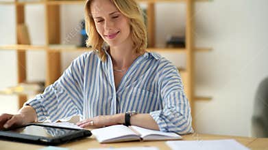 Attractive young self employed woman smiling into camera while working