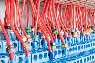 Many intermediate relays installed in a row. They are connected with many wires red with marking.