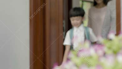 Asian parents opening door for son to walk out to go to school