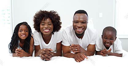 Happy family lying on bed in bedroom