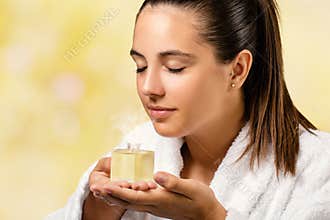 Young woman smelling essential oil fragrance.