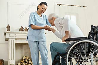 Pleasant senior man holding caregivers hand