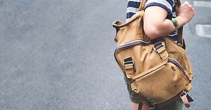 Close up backpack at back of woman traveler walking on street to