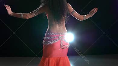 Slim torso of a beautiful belly dancer on a black
