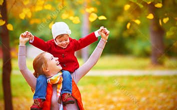 Happy family: mother and child little daughter play cuddling on