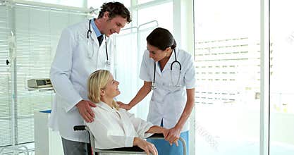 Doctors speaking with patient in wheelchair