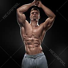 Handsome muscular bodybuilder posing on Front Lat Spread