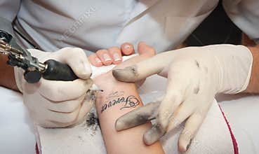 Tattooer does the tattoo