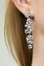 Close up of woman wearing shiny diamond earrings
